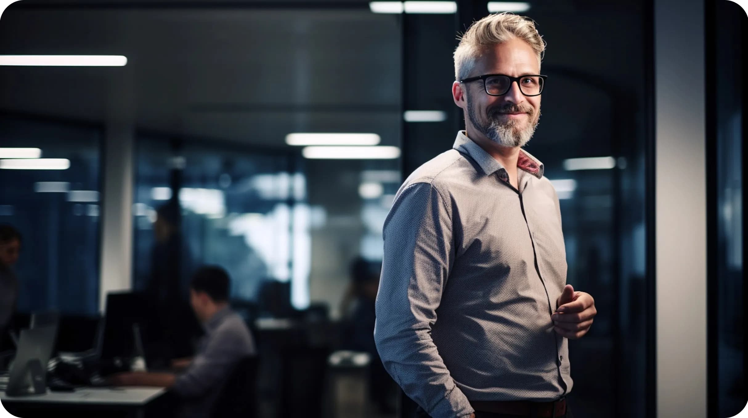 An elegant man smiling to the camera, standing in a office space