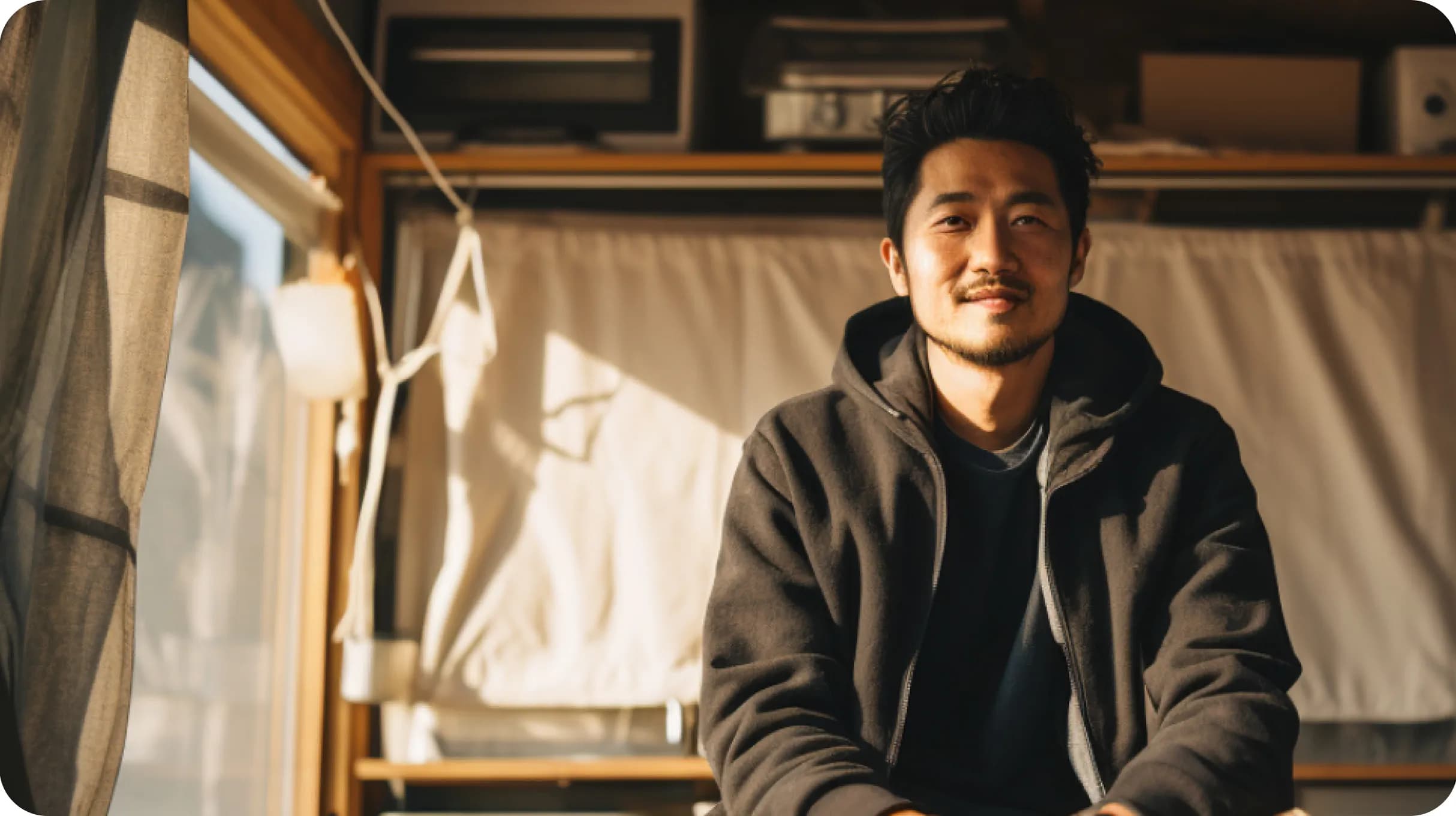An asian man sitting in a cabin with a window on a side
