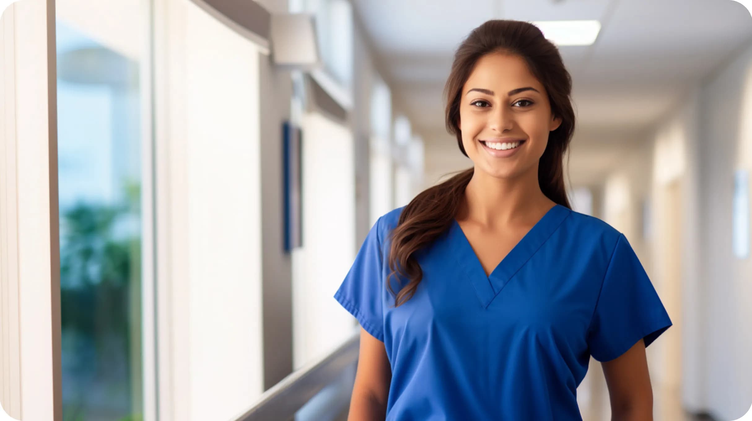 A young latin nurse in a blue suit standing in a hospital holl