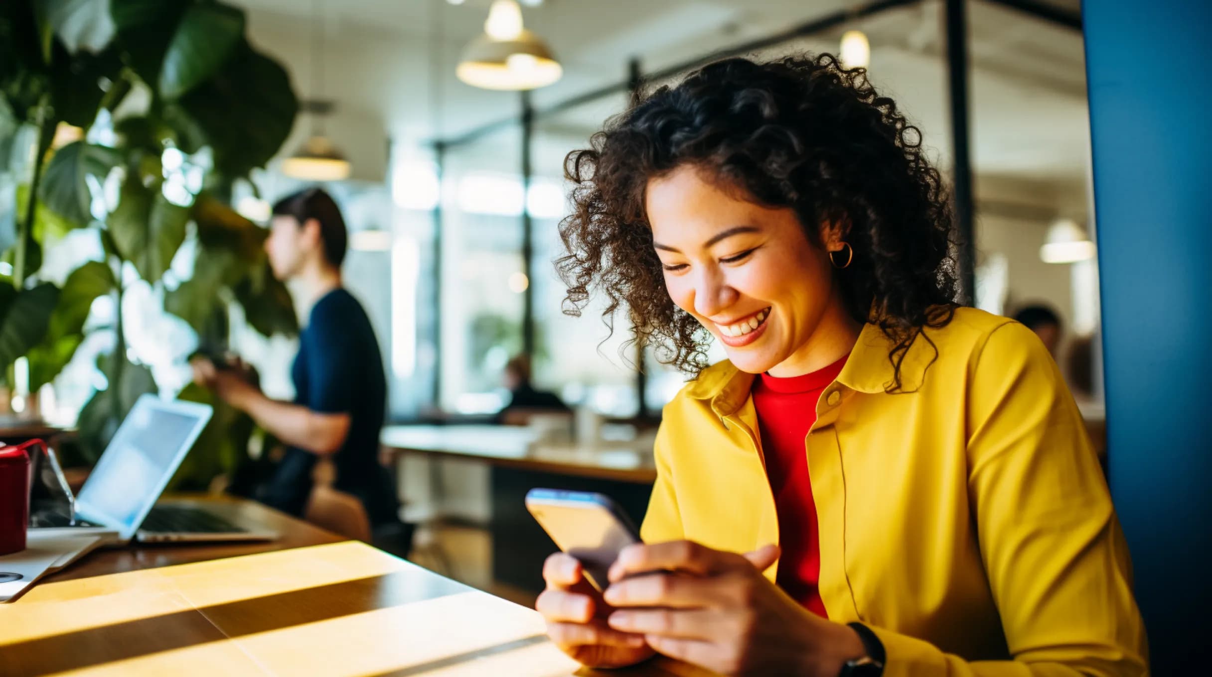 WOman sitting in an office and holding phone in hands