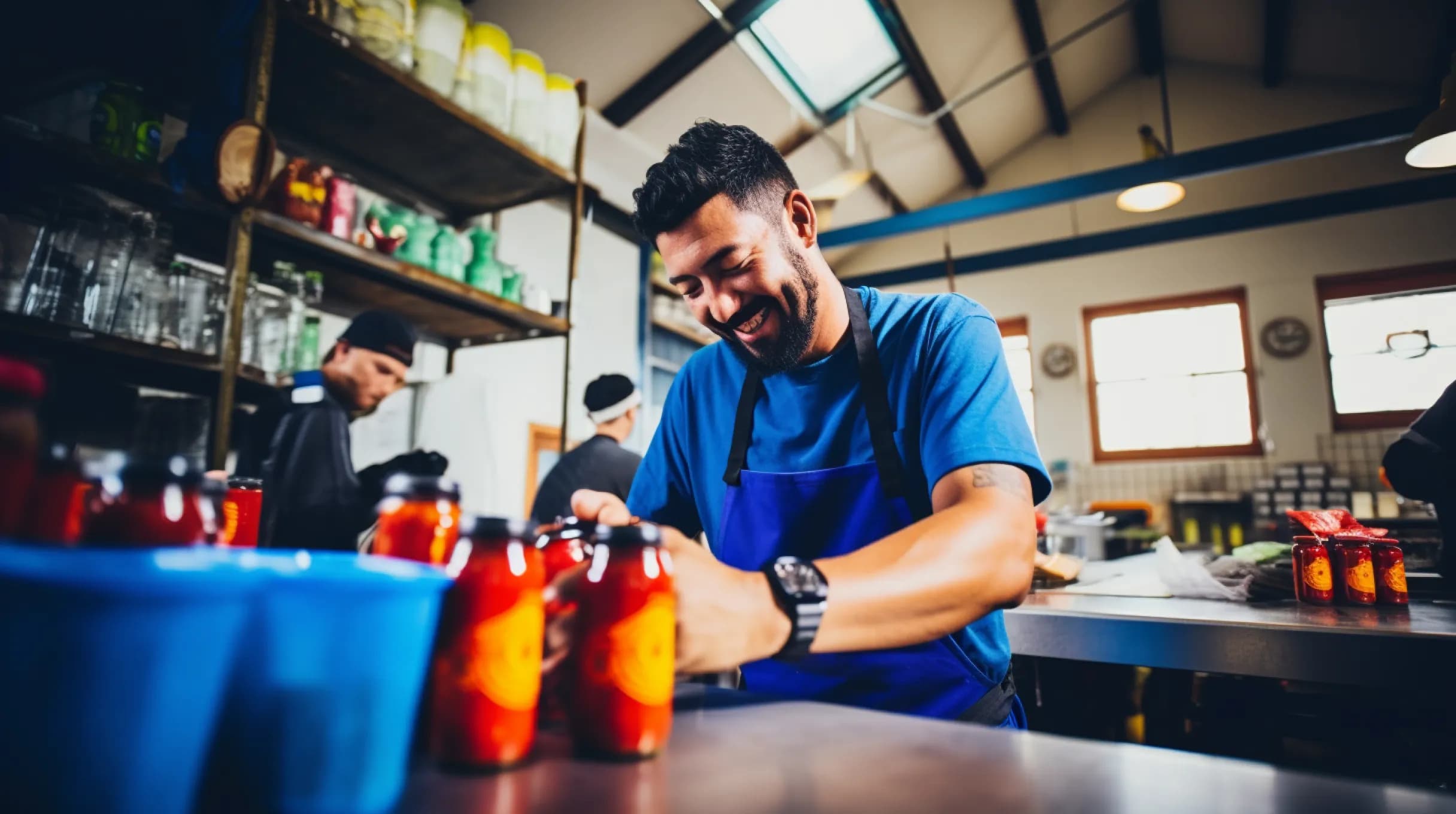 A worker in a factory handling bottles and cans, ensuring smooth production and quality control.