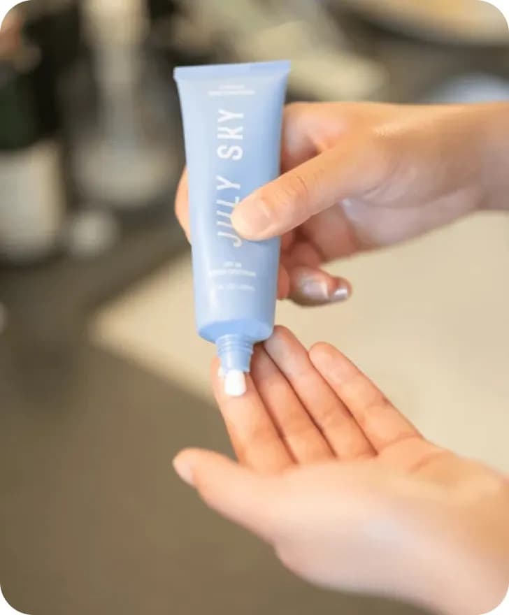 A woman holding skin cream of July Sky