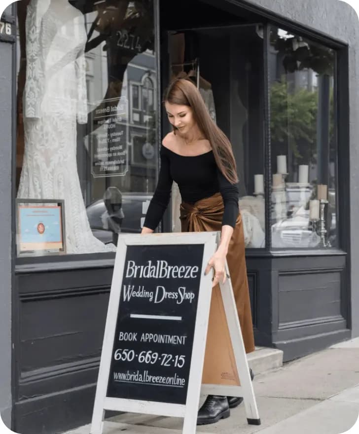 Marina Andriichenko next to the Bridal Breeze holding outdoor display board.