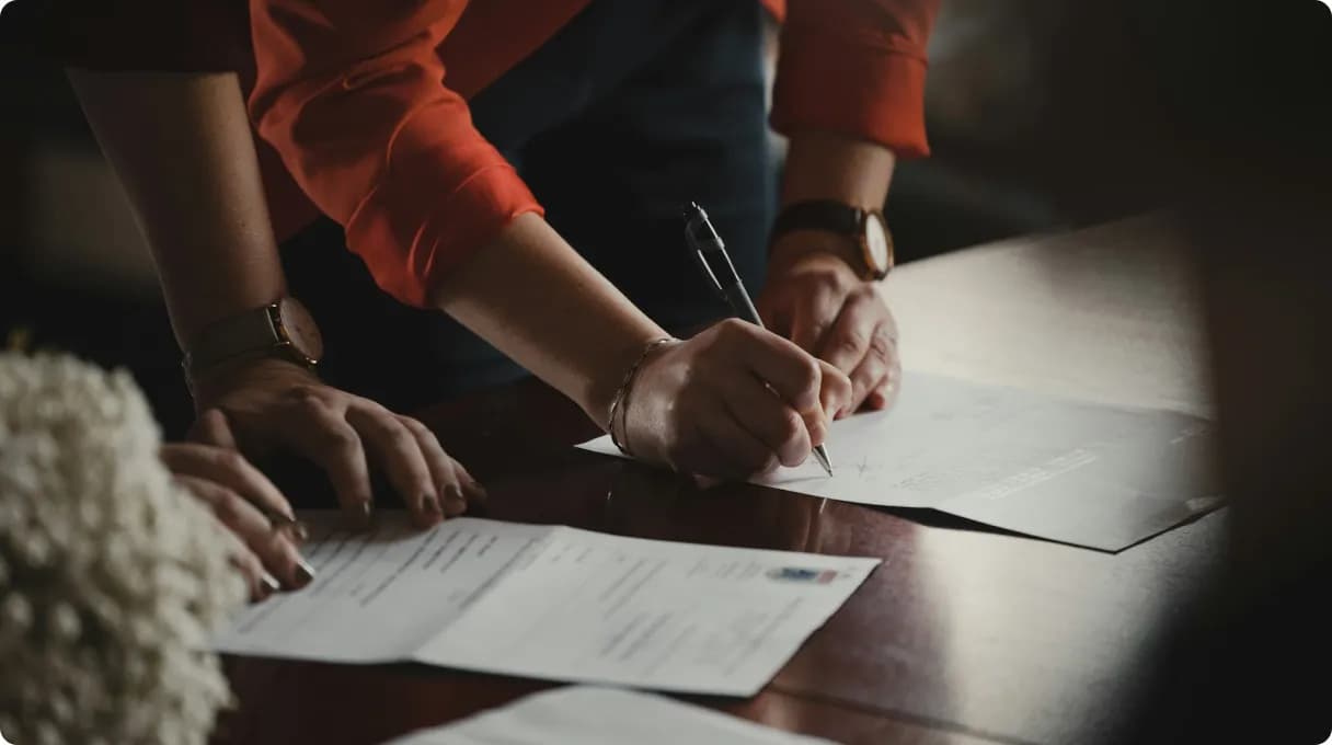 erson-in-orange-long-sleeve-shirt-writing-on-white-paper