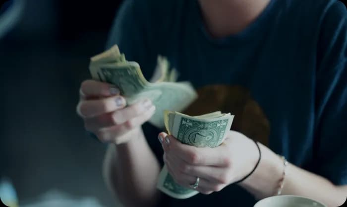 Focus photography of person counting dollar banknotes