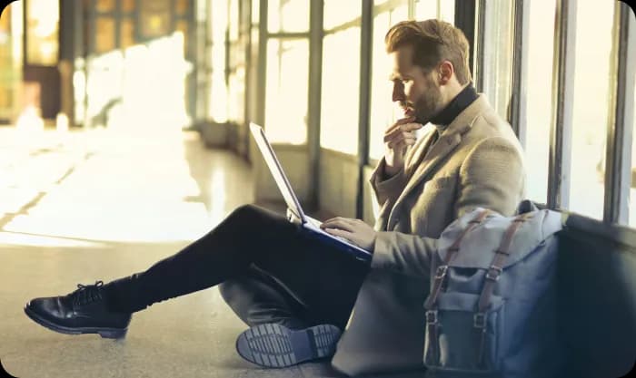 Man sitting on floor while using laptop