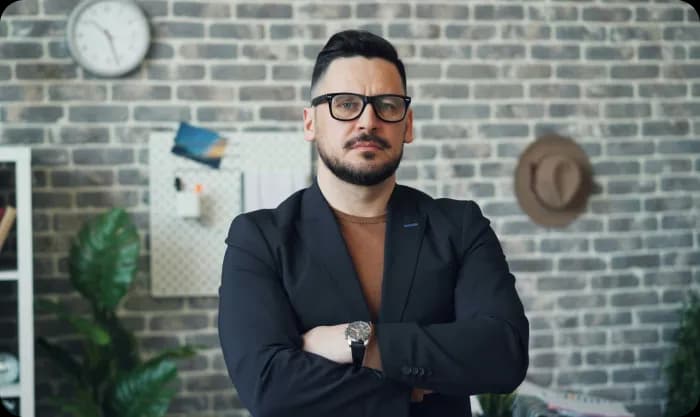Man with glasses and beard standing in office