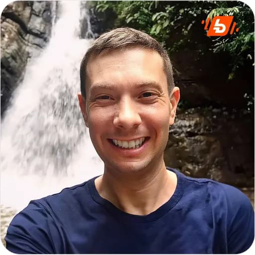 Adam Riemer is on the waterfall landscape, smiling at the camera.