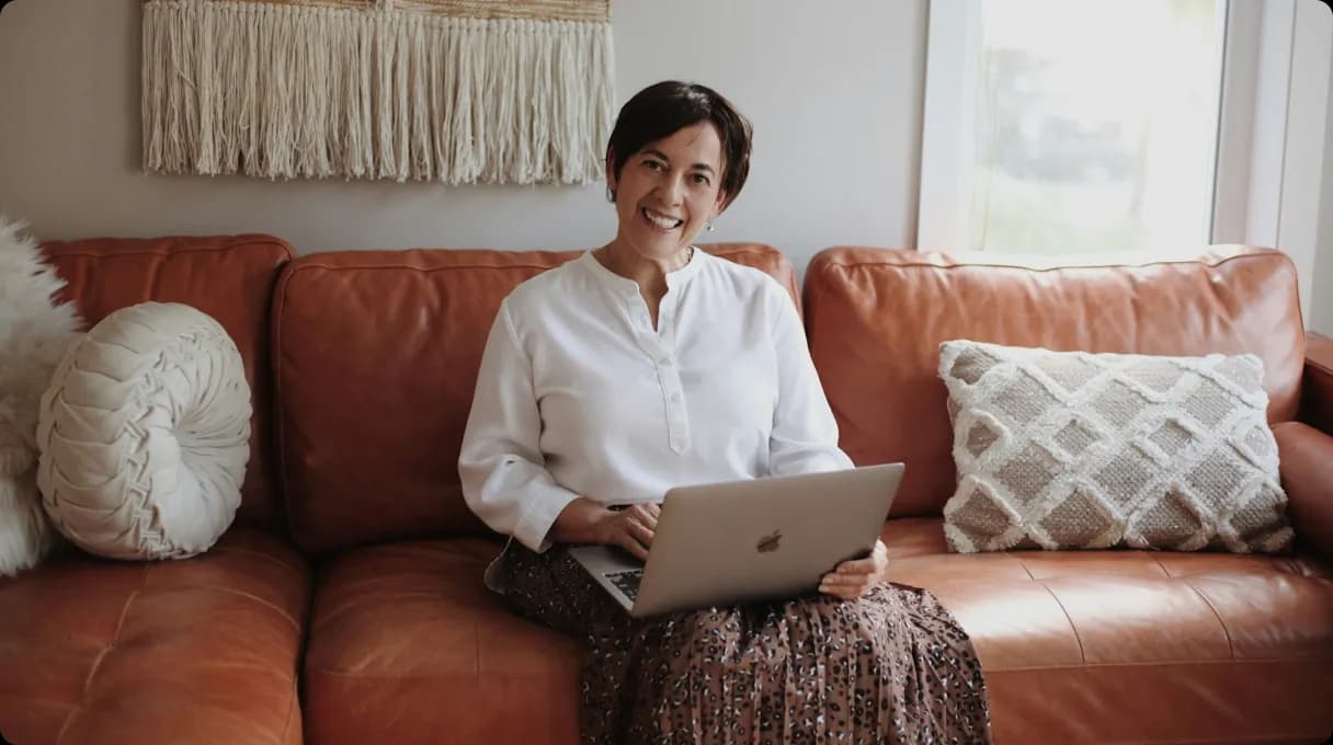 Woman sitting on couch with laptop
